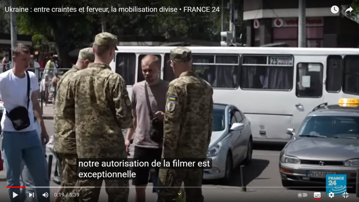 Патруль проверяет, не уклоняется ли прохожий от мобилизации. Скриншот с канала France24 с сайта YouTube