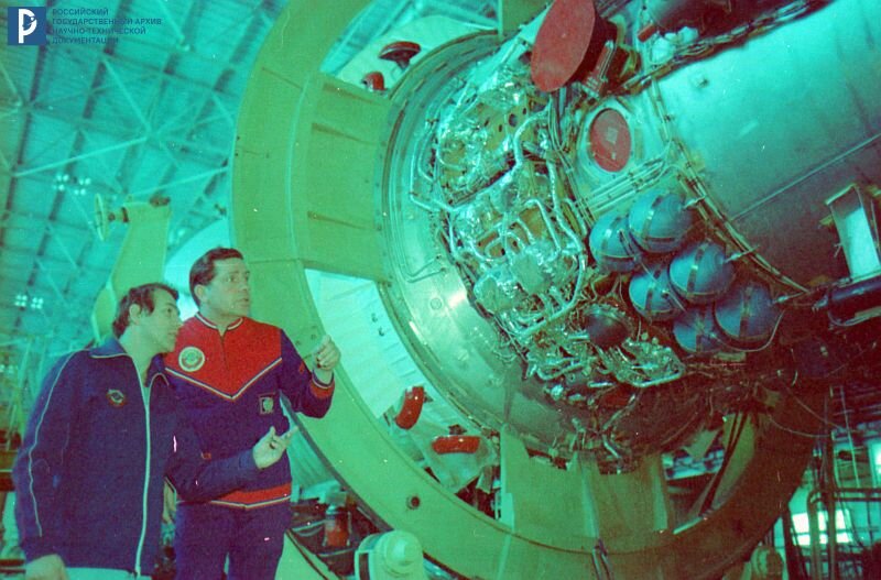 В.А. Ляхов и А.П. Александров осматривают орбитальную станцию «Салют-7» в монтажно-испытательном корпусе космодрома Байконур. 1982 г. РГАНТД. Арх. № 1-3857 цв.