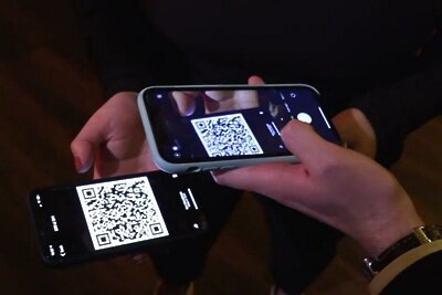    Мужчина со смартфоном сканирует QR-код в баре ©Роман Солдатов РИАМО