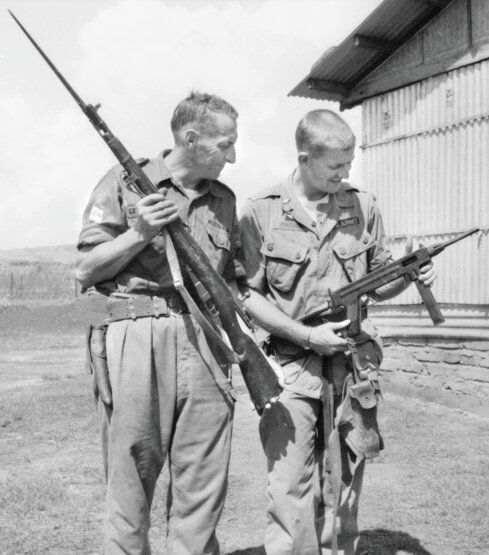 Австралийский офицер (с винтовкой Мосина) и американский солдат (с пистолетом-пулеметом Мадсен) осматривают оружие, захваченное у вьетконговцев.