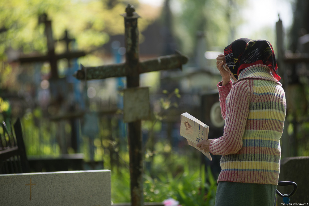 Можно убираться на кладбище в родительскую субботу. Человек молится на кладбище. Моление на кладбище. Родительский день на кладбище. Радоница на кладбище.
