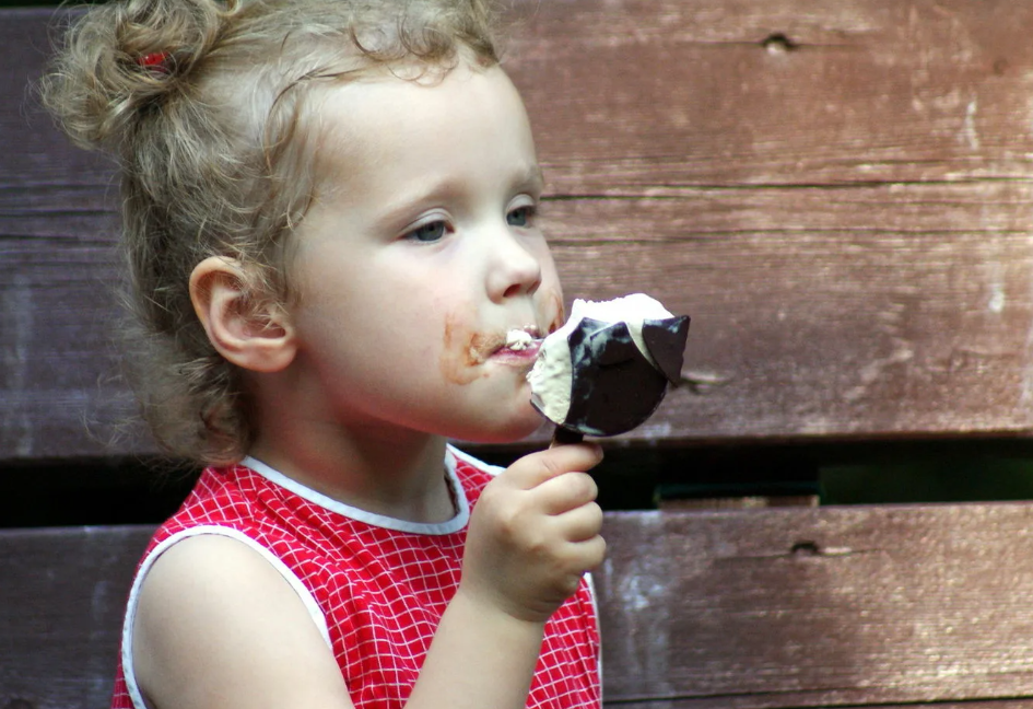 Девочка ест эскимо. Девочка с мороженым. Мороженое для детей. Дети едят мороженое. Девочка эскимо