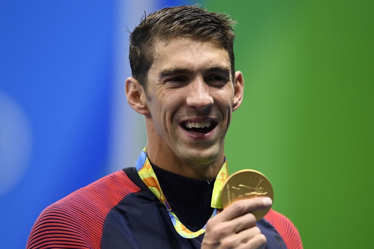 Майкл Фелпс (Michael Phelps) - американский пловец, родился 30 июня 1985 года в Балтиморе, штат Мэриленд. Он является самым успешным олимпийским спортсменом в истории, завоевав 28 олимпийских медалей, из которых 23 золотые. 
Фелпс начал заниматься плаванием в возрасте 7 лет, а в 15 лет уже выступал на Олимпийских играх в Сиднее, где завоевал свою первую золотую медаль. В дальнейшем он стал доминировать в мировом плавании, установив множество мировых рекордов и победив на многих международных соревнованиях.

Однако, помимо спортивных достижений, Фелпс также стал известен своими проблемами с наркотиками и алкоголем. В 2014 году он объявил о завершении карьеры, но вернулся на Олимпийские игры в Рио-де-Жанейро в 2016 году, где завоевал еще 5 золотых медалей.

Сейчас Майкл Фелпс продолжает работать в спорте, в том числе как комментатор и тренер.
