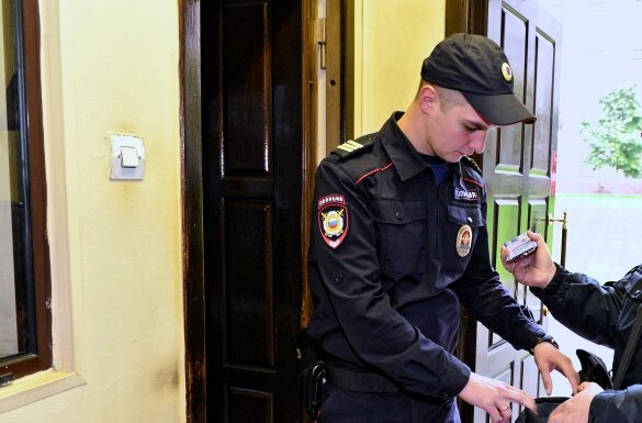 Настоящий профессионал может одновременно изучать предъявленные документы и проверять содержимое сумки. Фото из открытого доступа.