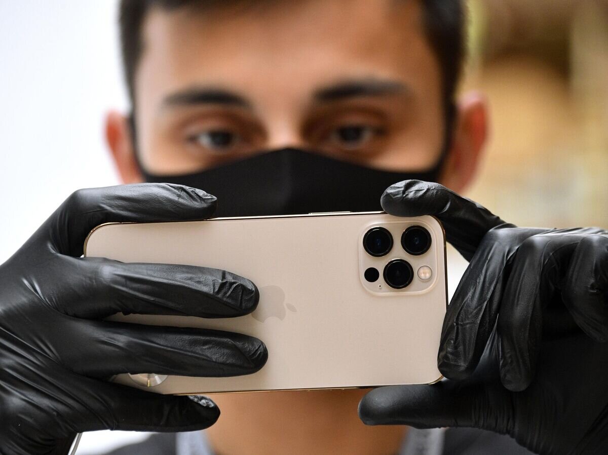   Молодой человек держит в руках новый iPhone 12 Pro© РИА Новости / Евгений Биятов