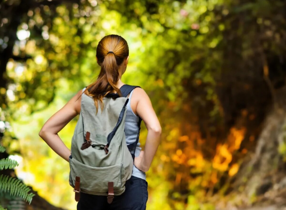 Девушка с рюкзаком в лесу
