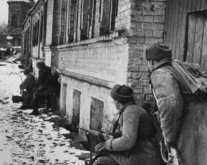 Советские солдаты осторожно продвигаются по улице города.
