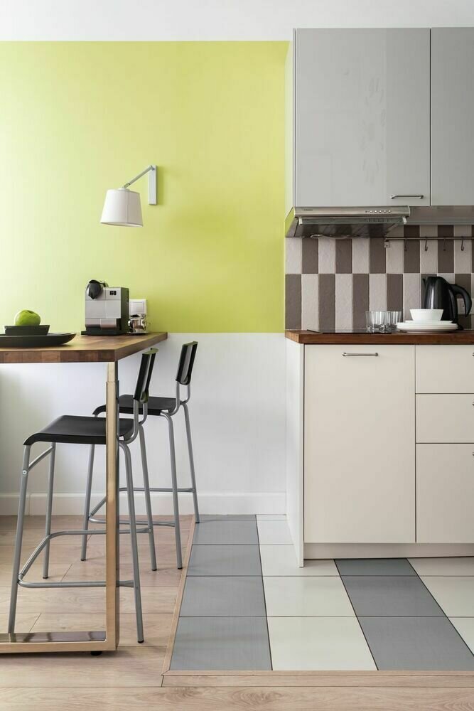 Кухню и гостиную зонировали барной стойкой, которая выполняет функцию обеденного стола. Металлические детали вкупе с неоновыми элементами отделки вносят в интерьер общей зоны нотки стиля хайтек.