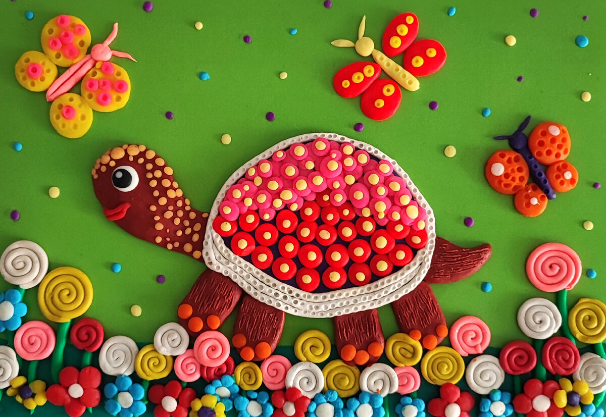 Готовый вариант аппликации из пластилина на цветном картоне " Разноцветная черепашка в цветах".