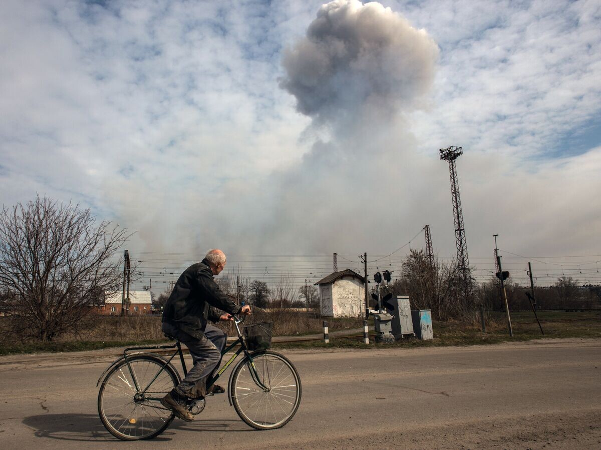    Мужчина на велосипеде на одной из улиц города Балаклея в Харьковской области во время пожара на военных складах боеприпасов© РИА Новости / Стрингер