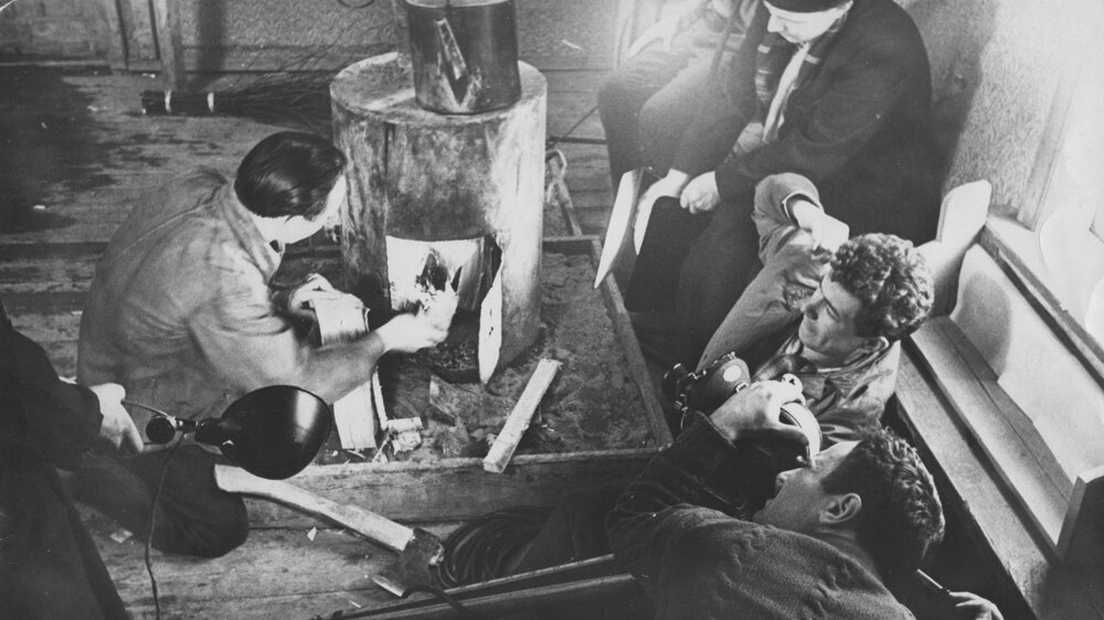 Рабочие разводят огонь для бани. 