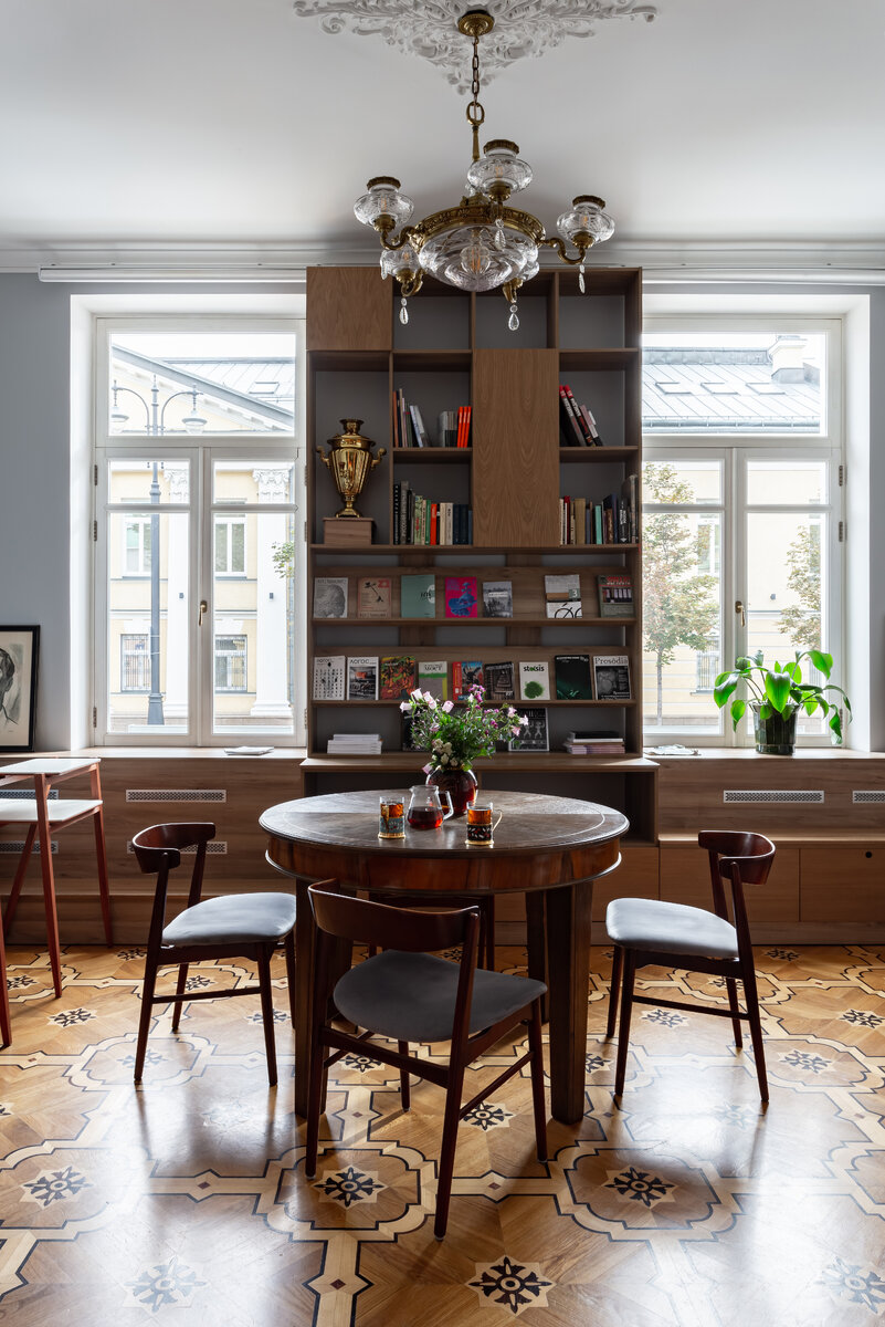 Над столом испанская люстра середины ХХ века и винтажные датские стулья.