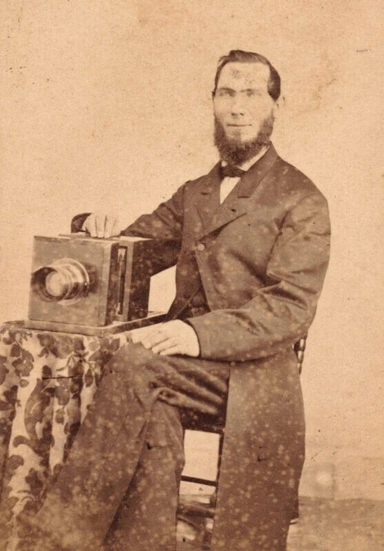 В то время как камеры в середине 1800-х годов уже были относительно портативными, проявка мокрой пластины делал прогулочную фотосъемку трудной, если не невозможной. На этой фотографии изображен фотограф из Мэриленда по имени Генри Б. Грэммер со своей камерой в 1860-х годах.