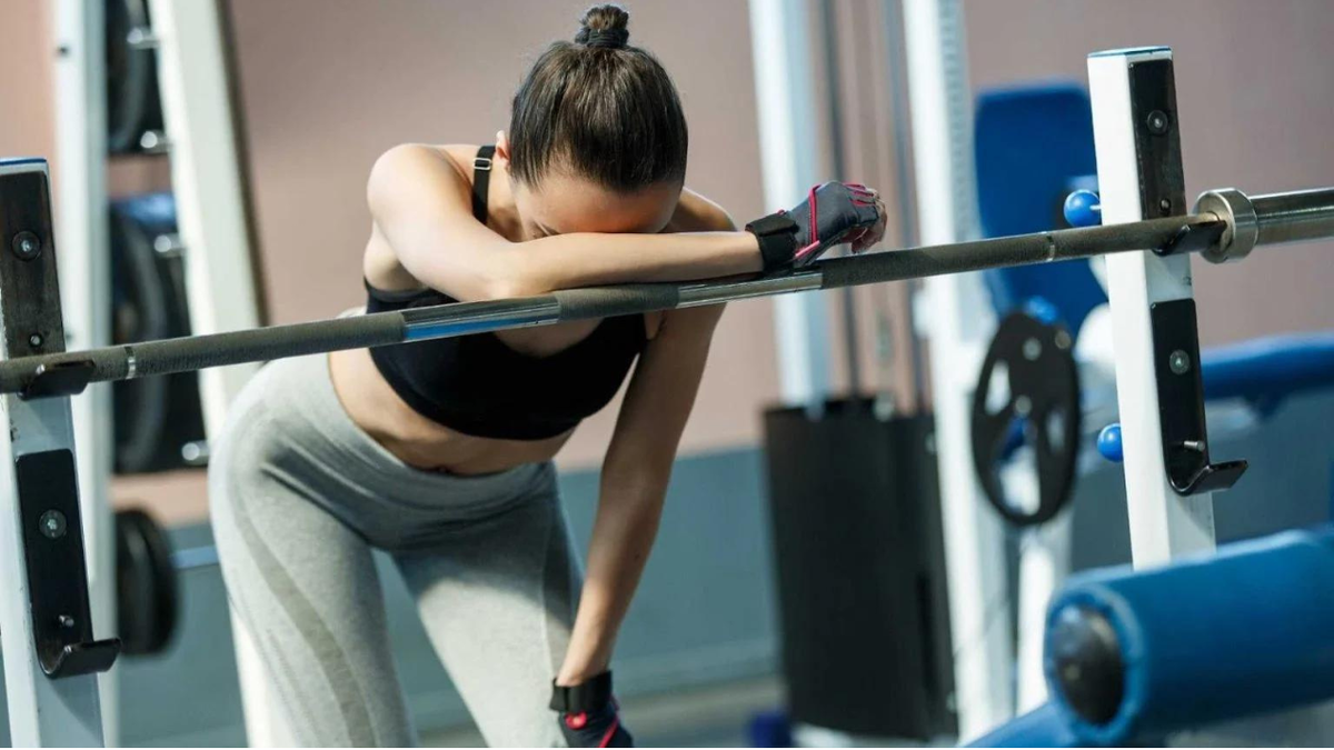 Тренировка усталость. Девушка уставшая в зале. Девушка уставшая в фитнес зале. Девушка устала в спортзале. Человек тренируется.