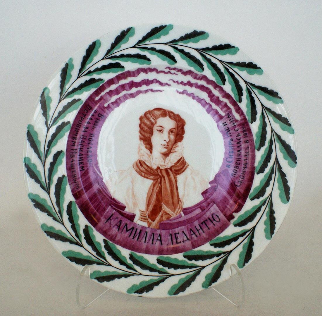 Тарелка с портретом Камилы Петровны Ивашёвой (урождённой Камилы ле Дантю). ГФЗ, 1920. Роспись надглазурная полихромная. Размеры: 3,4х22,3 см. Собрание Эрмитажа. Предмет поступил в 2002-м году. Передан в составе коллекции Музея Фарфорового завода. Инв. номер Мз-С-906. Изображение взято из каталога Эрмитажа.