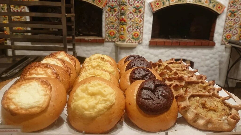 Шаньги с разными поливами (слева направо: творожной, картофельной, черёмуховой) и калитки с картофелем в новосибирском магазине русской кухни «Добрянка». Фото Максима Сырникова