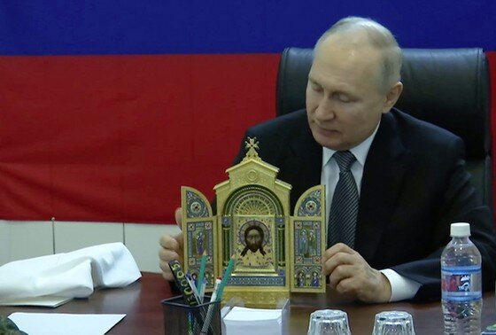    Президент РФ Владимир Путин вручает копию иконы военнослужащим во время посещения штаба группировки «Днепр» на Херсонском направлении