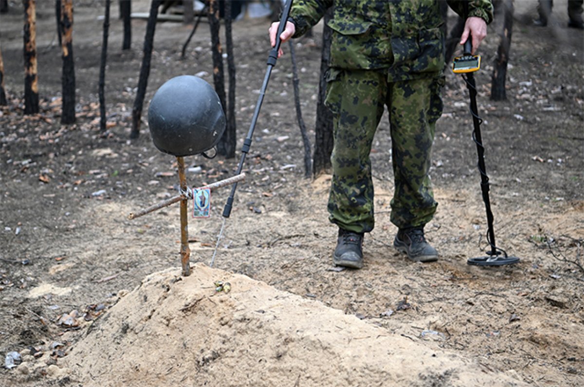    Сапер Росгвардии обследует могилу на территории бывших позиций ВСУ.