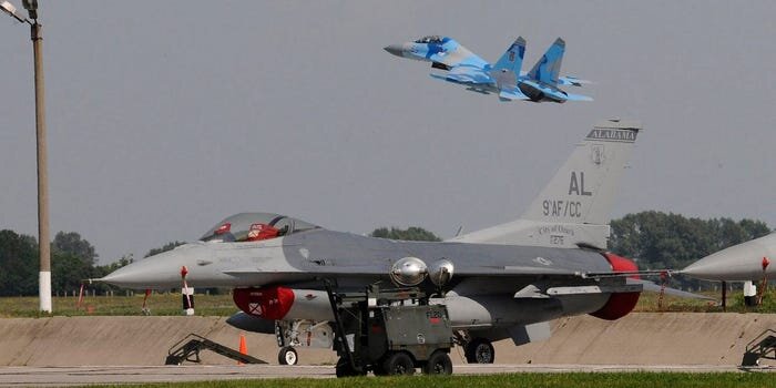 F-16C Национальной гвардии США на авиабазе Миргород, украинский Су-27 взлетает в июле 2011 года.
