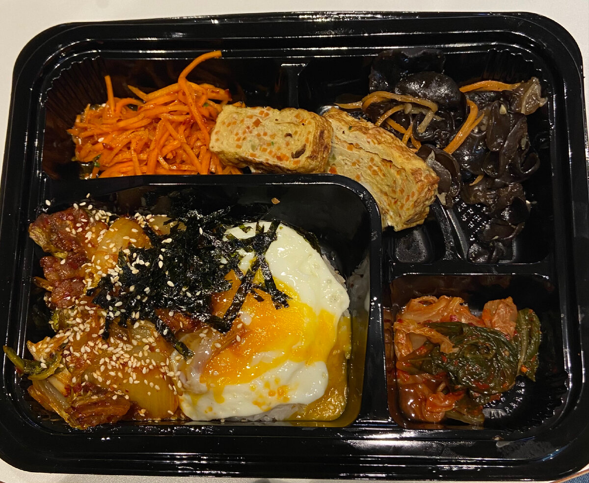 Это «Доширак кимчи поккымпаб» (489 руб). Комплексный набор из традиционных салатов, супа, горячего и закуски. Состав: Морковь-ча, кимчи, маринованный дайкон, мисо суп, рис, свинина с кимчи и яйцо, омлет. Да, суп не сфотал, но он был. В целом это вкусно, сытно, но на очень голодного человека. Так как в Корее любят острое, то этот «Доширак» подойдет не всем, потому  практически все блюда в нем острые и приходится запивать