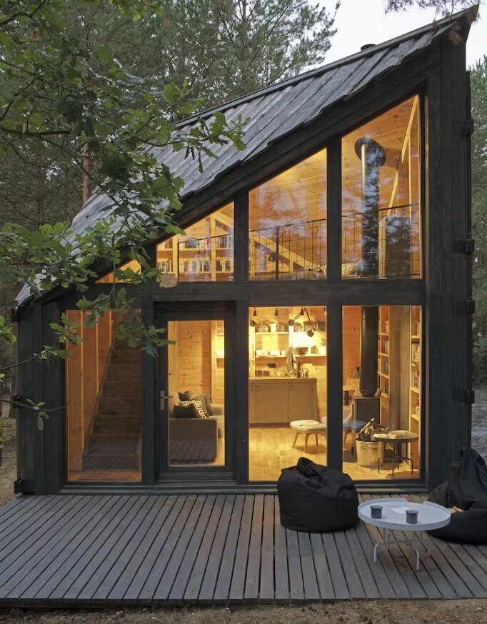 Окна от пола до потолка на переднем фасаде кабины позволяют гостям любоваться видом на лес и песчаные дюны.