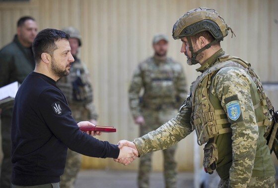    Владимир Зеленский вручает боевые медали украинским морским пехотинцам во время посещения передовых позиций