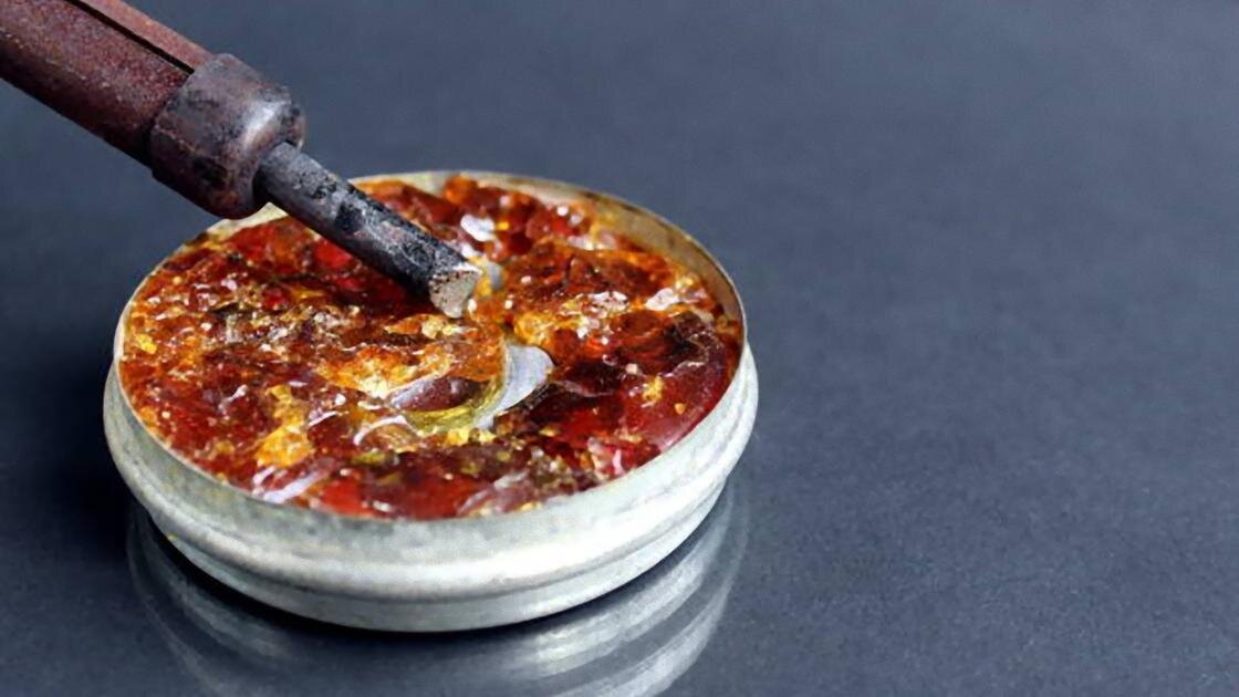    Канифоль в жестяной коробке набирают на паяльник:iStockPhoto