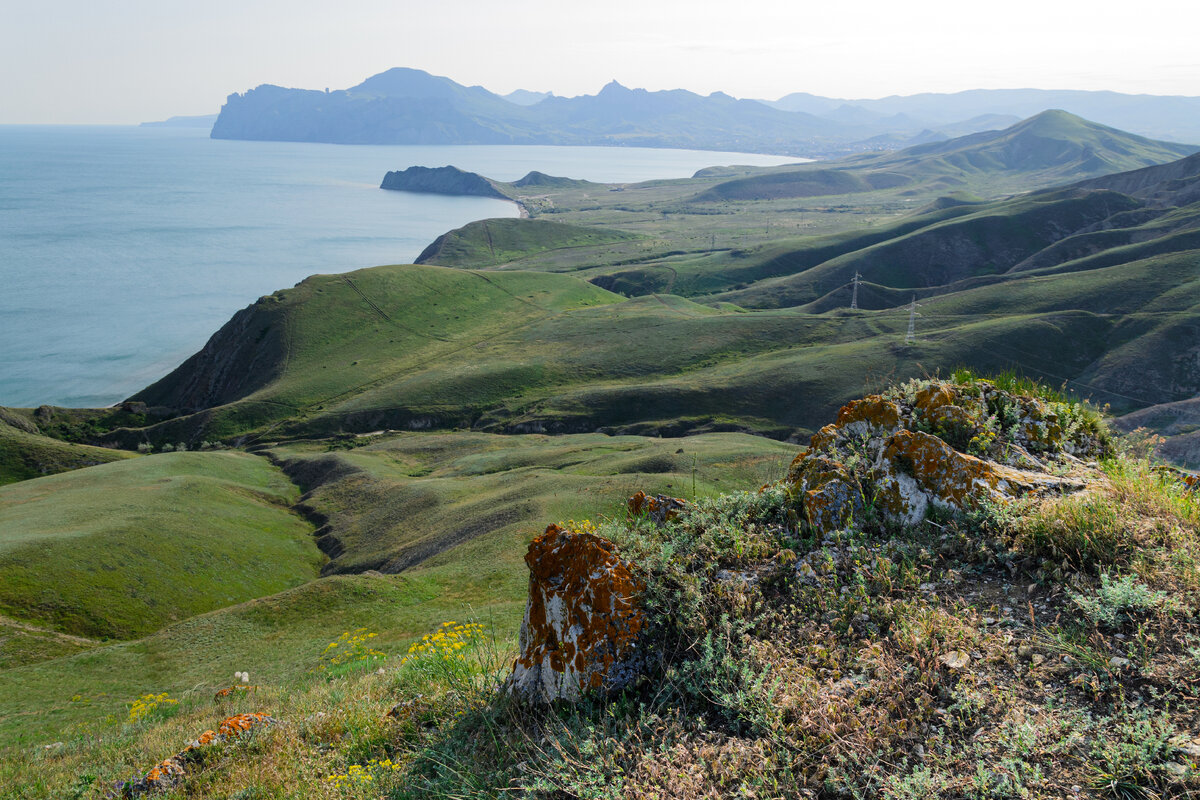 Мыс Хамелеон и силуэт Карадага, между ними бухта Коктебеля.