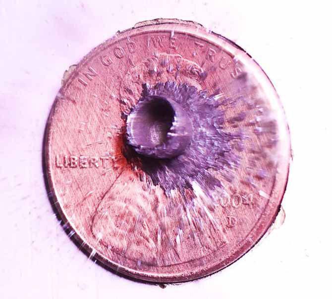 Резиновая пуля в момент попадания в монетку