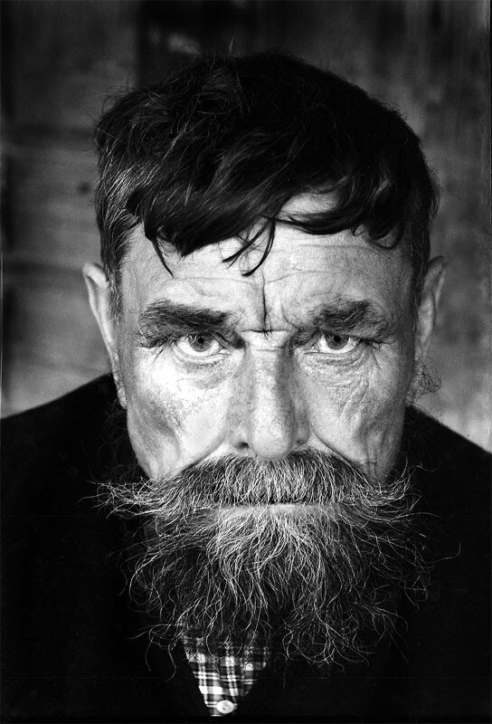 СИЛЬНЫЕ ЛЮДИ 

Случился некий казус, я не дал человеку кружку воды, просто сказал, что нет и всё. Не очень приятная история, но была и предыстория. 
Пару дней до этого, зашёл в мою мастерскую этот тип, похоже, у него был до этого весёлый вечер и бурная ночь. Средне опухшая физиономия, запах плохого пива и кислотабачный парфюм выдавали его состояние. Попросил воды, ну я и налил ему в кружку, выпил он и побрёл поближе к своему месту работы. 
  
Вот только от моей кружки теперь исходил жуткий запах. Пробовал отмыть, но уже сработала психология, я просто выбросил вонючую посудину. И вот теперь выдал ему, что не дам, я пожилой человек, приношу чистую воду из дома, он молодой и способен сам обеспечивать себя. Про провонявшуюся кружку я ему не стал говорить, не поймёт ведь, внутренне он считает себя правильным парнем. 

В отместку он обозвал меня «семейником», у них тоже воды не выпросить. Семейниками, на его родине, называют старообрядцев. Этому запивохе сложно понять, запах перегара и табака не всем нравится, вот я и попал в «семейники». 

Знал бы он, что мои корни тоже идут от старообрядцев, только уральских. И мне ни сколько не зазорно такое сравнение, скорей это даже предмет гордости. Дед мой прекрасно читал книги на старославянском, был уважаемым человеком не только у единоверцев. 
  
Ещё в Первую Мировую он был призван в армию, участвовал в Брусиловском прорыве. Получил ранение, осколок снаряда повредил руку, сделал его инвалидом. Вернулся домой, тут революция, Гражданская война. Про эти времена в его жизни я мало знаю. Но в дальнейшем он много работал на руководящих должностях. Всё его образование была церковно приходская школа, но природные способности позволили освоить всякую работу. Он руководил колхозом, потом мельницей. Был даже судьёй в районном суде, пока не появился юрист с образованием. Естественно он был членом Партии Большевиков.  
Бабушка, конечно, расстраивалась, всё - таки он слегка отступал от правил старообрядческой церкви. Одно время случился у него перерыв в работе, бабушка уговорила его читать им книги на молебнах, мало кто уже понимал старославянское письмо. А службы велись по старым книгам, ведь старообрядцы не дружили с никонианами. 

Дед и стал читать старые книги на молебнах, дело – то хорошо знакомое. Узнала про это сельская партячейка, вызвали его и устроили ему разнос. Учитывая его прежние заслуги, обошлось выговором. В те времена исключение из партии могло повлиять даже на жизнь детей исключённого. 
  
Вот только есть одна беда в нашем роду. Отследить прапрадедов крайне сложно. В период репрессий тридцатых годов, старики решили спрятать церковные книги подальше от властей. Один из старейшин был отправлен на дальнюю заимку с церковным архивом. Книги, где были записаны, кто и когда родился, был повенчан с кем, когда умер, было решено спрятать до лучших времен. Так и сделали. Вернулся из лесу посланец уже в конце пятидесятых, без книг и почти без памяти, не мог толком сказать, что произошло за эти времена. Ходили в лес, искали по заимкам, но результатов никаких. Так что о предках я могу знать только из рассказов отца. Дед мне ни чего не рассказывал, поскольку я был слишком мал, когда он был ещё жив. Про своего прадеда знаю, его звали Истафей, но даже мой отец его не застал живым, вот такая история с биографией. 

Мало помню из разговоров взрослых, запомнилась одна фраза. Разговаривали о каком– то из своих, тот человек сказал, что помрёт к Покрову. Говорили, что посмеялись над его словами и забыли. Но на Покров этот человек обошёл своих друзей, поговорили по пустякам, утром, он уже лежал в избе на широкой скамье со свечой в руках, все зеркала были завешены платками, притихшая родня готовилась к похоронам. Тут и вспомнили его слова, вообще старообрядцы уходили в мир иной спокойно, помолившись и покаявшись, поручая свою душу Создателю. 

Такими их сделала жизнь, твёрдость в вере и многолетние гонения официальной церкви. 
  
Следующее, запомнившееся событие, связанное со старообрядцами было уже в приличном возрасте. Разговорились в поезде с попутчиками, разговор как – то сам склонился к старообрядству. Вспомнили, кого знали из этих людей, чем знамениты были в своих краях. Попутчик один был с Урала, знал этих людей не понаслышке. Рассказал довольно необычную историю. 

Ещё молодыми пацанами решили они своей компанией, среди зимы сходить на лыжах в поход. Долго выбирали маршрут, потом уговаривали родителей отпустить их. Когда вся подготовка закончилась и выступили. Шли где лесом, местами по замёрзшим речкам, ночевали по - таёжному, в лёжках выстланными лапником. Чистый воздух, вечерний костёр, сколько романтики. Беда пришла тихонько, без предупреждения. Метель. 
День, другой можно переждать, но надо выходить к людям, припасы дорожные не бесконечны. Вот и пошли, вроде по карте и компасу. Разве что карта взята из школьного атласа, кто её составлял, не подозревал, как её будут использовать. Шли несколько дней, конечно, сбились с дороги, просто шли и всё, если остановиться может быть совсем плохо. На какой-то день пути один из парней просто упал и не поднялся. Попытки его растормошить, ни чего не дали. Снег падал на его лицо и не таял, он был мёртв. Кое-как привязали его к лыжам и тянули из последних сил, бросать было нельзя. Развели костёр среди камней, пытались сделать себе чай, непослушные руки не держали кружки, но чай оказался живительной влагой, только кружки подавали чьи-то чужие руки. Плохо запомнилось дальнейшее, какое-то покачивание, голоса и всё. 
Очнулись в тёплой каморке, на столе стояли чашки с тёплой кашей, хлебом и какое-то ароматное питьё в горшке. Когда головы приобрели способность соображать, вспомнили замёрзшего товарища. Стало жутковато, что скажем дома, как объясним его родителям. 
В низкую дверь протиснулся мальчишка, принёс горячий чайник и чугунок с парящей картошкой. Спросили его, есть ли взрослые в доме, парнишка, молча, кивнул и вышел. Через какое-то время за дверью послышались шаги и тихий говор. Вошёл бородатый мужчина, перекрестился на иконы в углу каморки и произнёс в сторону двери: «Заходи, чего мешкаешь». Когда мы увидели вошедшего, онемели от неожиданности. Перед нами стоял, слабо улыбаясь, наш замёрзший до смерти товарищ. Бородач тихо произнёс: « И не таких выхаживали, повезло вам, охотники домой возвращались, подобрали вас». Прожили мы у них несколько дней, пришли в себя полностью. 
  
Пришёл уже знакомый уже бородач, велел собираться домой, пора. Одели нас уже в свою, более походную одежду. В ночь вышли на лыжах. Тёмной, безлунной ночью шли с короткими привалами, бородач молчал. Уже на рассвете вышли к накатанной санями дороге. Бородач сказал, к полудню будет идти санный обоз, подберёт и показал направление к нашему дому. Надо было просто не сбиваться с дороги и ждать пока догонят обозники. Перекрестил нас двумя пальцами на дорогу и так же, молча, скрылся в лесу. По сей день неизвестно, где всё это произошло, что это были за люди, умеющие жить в глуши. 

Возможно, парни набрели на село старообрядцев, им просто не показали где это и как там живут, меньше знают - крепче спят. Зря старался запивоха, называя меня «семейником», ему не понять силу этих людей. 

Геннадий Митрофанов

источник: http://www.proza.ru/2017/07/16/587

фото: "Твердый", Юг Cталинградской области. Старообрядец-безпоповец Сергей, 1976г