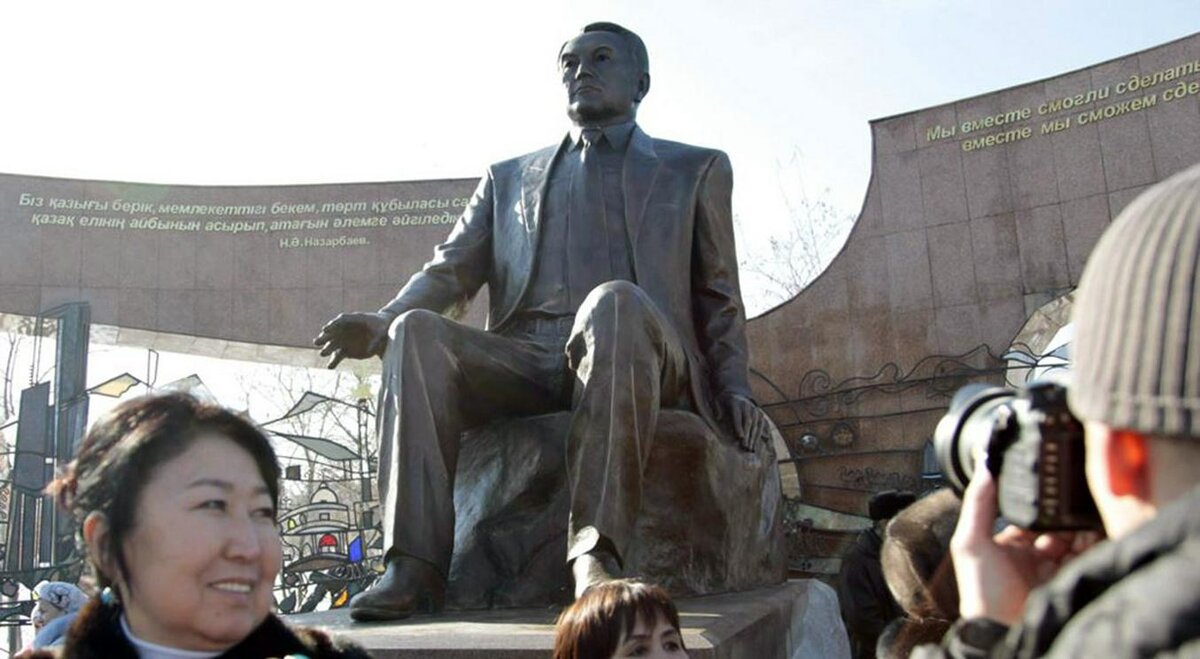 ЛЮДИ ФОТОГРАФИРУЮТСЯ НА ФОНЕ ПАМЯТНИКА НУРСУЛТАНУ НАЗАРБАЕВУ В АЛМА-АТЕ. ФОТО С САЙТА AZATTYQ.ORG