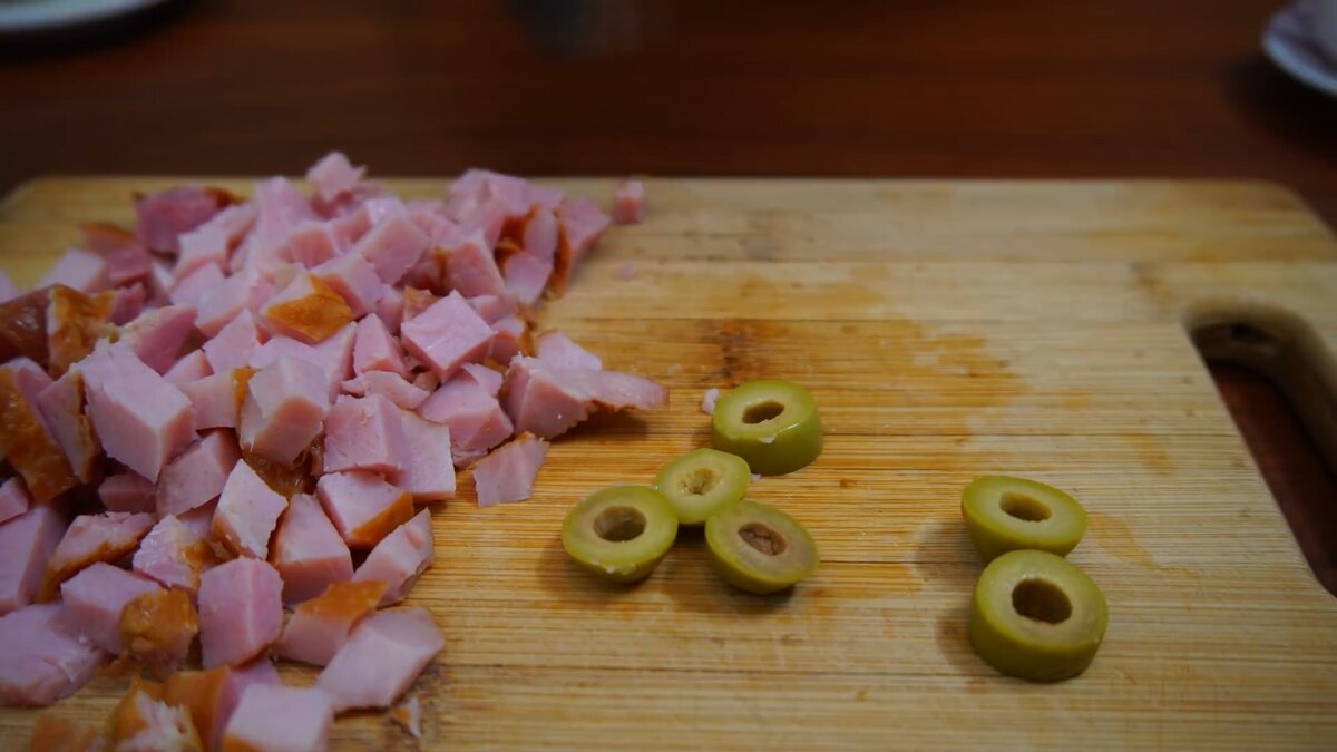 Оливки режем поперёк на 3-4 части, не мельчим чтобы в дальнейшем сильно не высохли. Ветчину режем квадратиками как на фото.