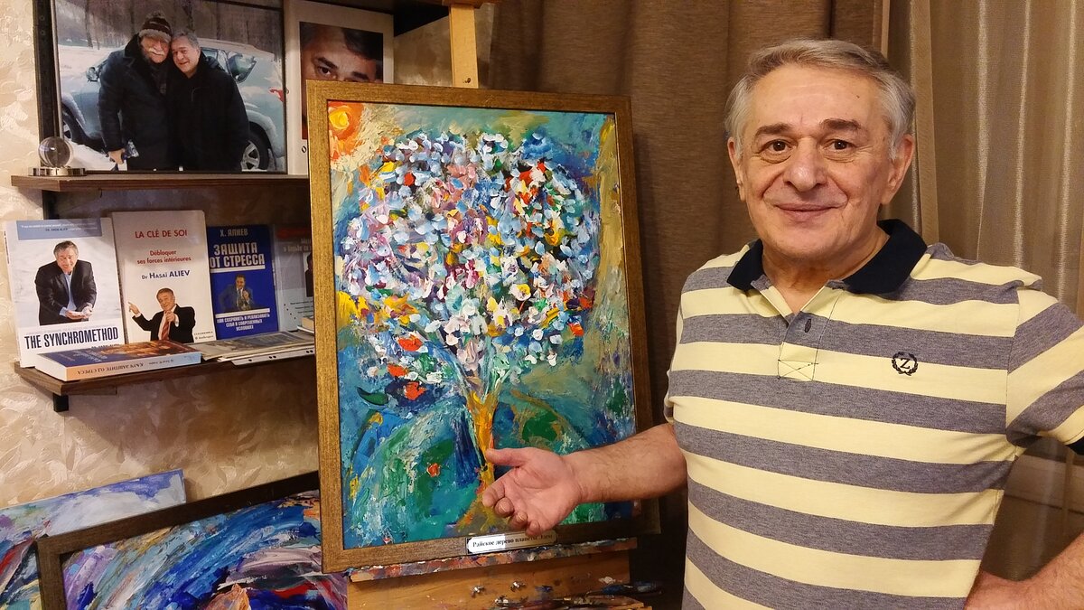 Д-р Хасай Алиев у своей картины "Райское дерево планеты Эдем", которую только что привезли с выставки из МГИМО 