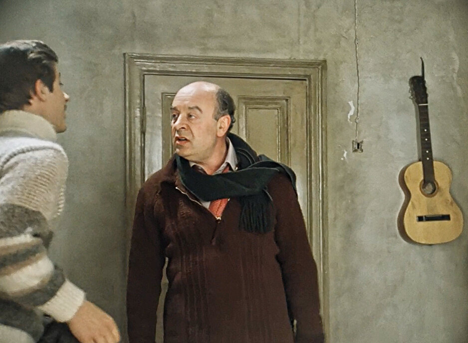 у входа напротив полок с книгами, перед шкафом