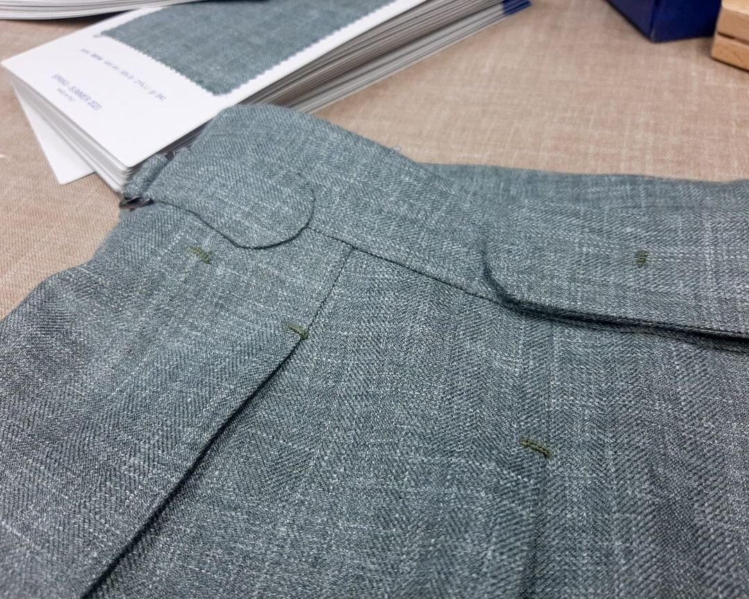 Легкие летние брюки из шерсти с шелком и льном в елочку от Caccioppoli в ателье Bourbaki. Брюки снабжены широким поясом, удлиненным переходником со скрытой застежкой, боковыми регуляторами объема и двойными защипами.