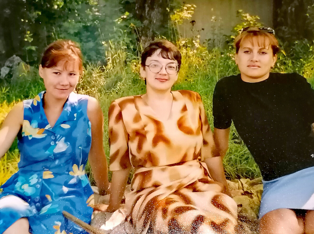 Я - начальник лагеря, сижу между воспитателями на травке, а дети гуляют на площадке