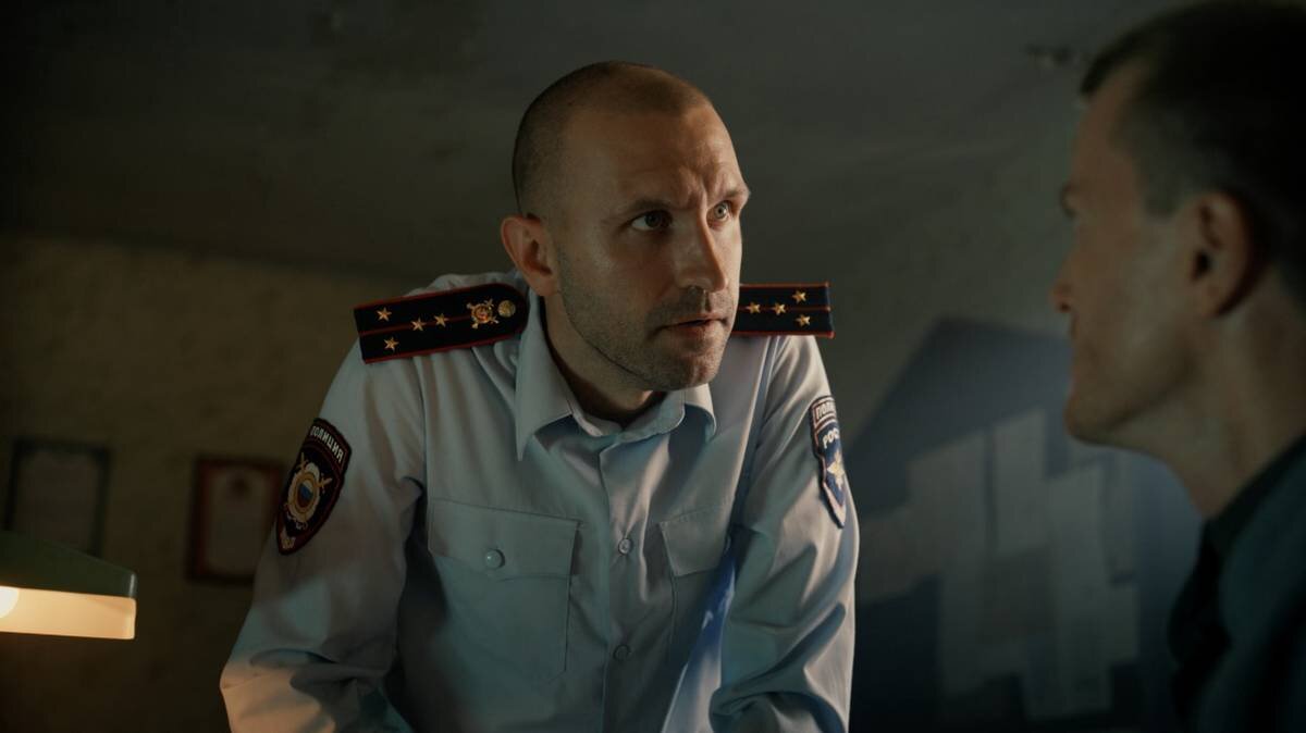    Кадр из комедийного сериала «Райцентр» (2023): Иван Добронравов (слева) в роли полицейского Васи. Ради этого проекта актера побрили налысо / Фото: Пресс-служба онлайн-кинотеатра «ИВИ»
