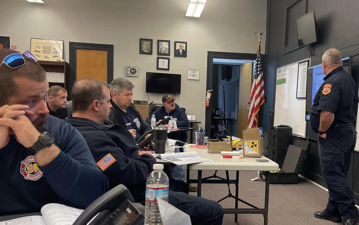 Я четвертый слева. На столе коробочка со значком радиоактивности - это не муляж, мы действительно тренировались на радиоактивных материалах, конечно слабо радиоактивных.