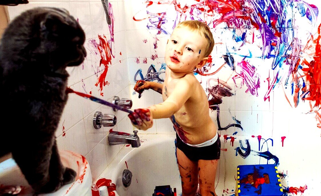 Маленький мальчик красит кота