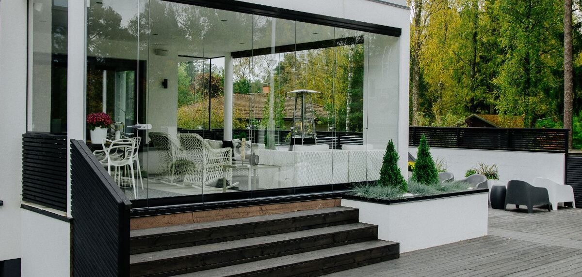 Газовые фонари для вечера и мягкая мебель на террасе с остеклением