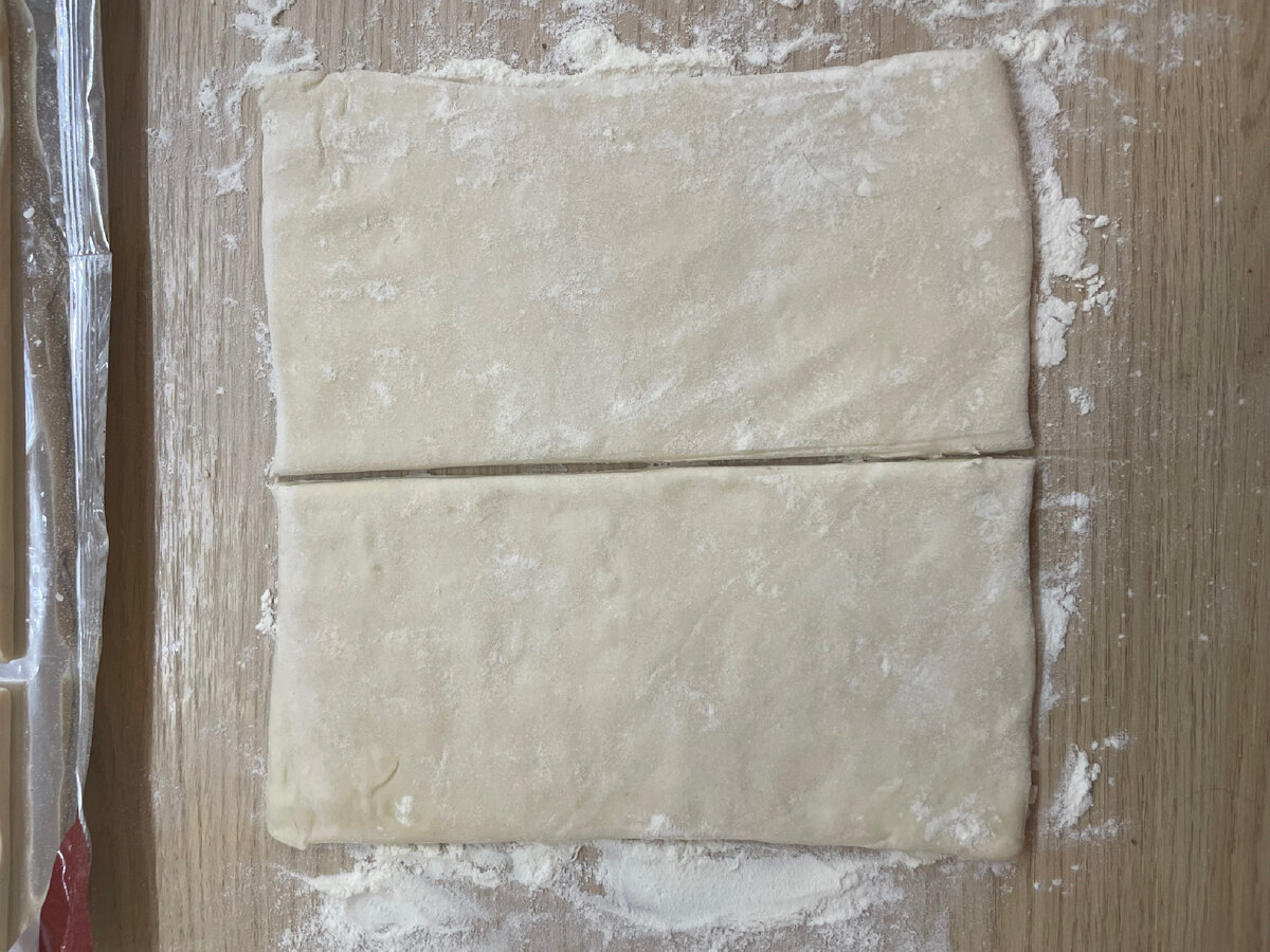 Немного раскатать скалкой тесто ,присыпанное  мукой,и разрежьте напополам  