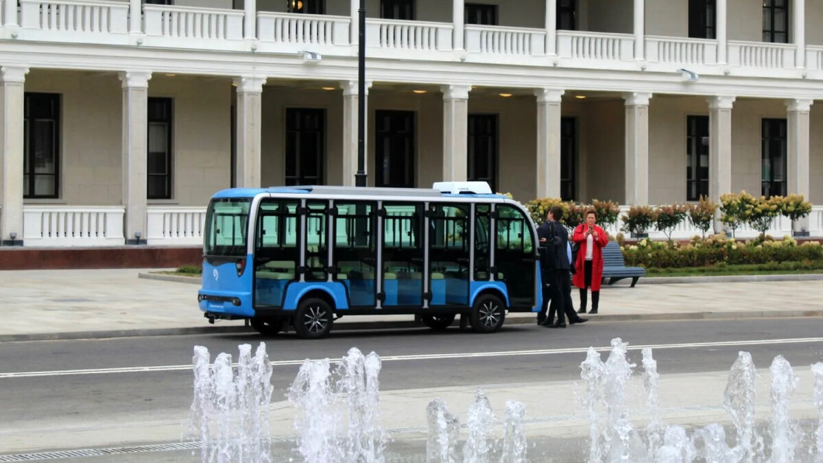 Маленький электробус у здания Северного речного вокзала