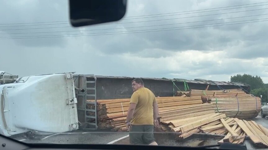     На выезде из Минусинска произошло ДТП: на мокрой дороге перед кольцом опрокинулся большегруз с досками. Прицеп перекрыл половину дороги.