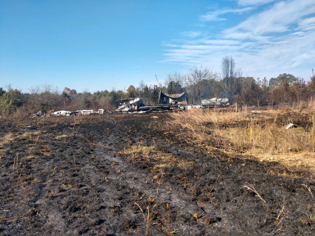 сгоревшая трава и остатки мобильного дома