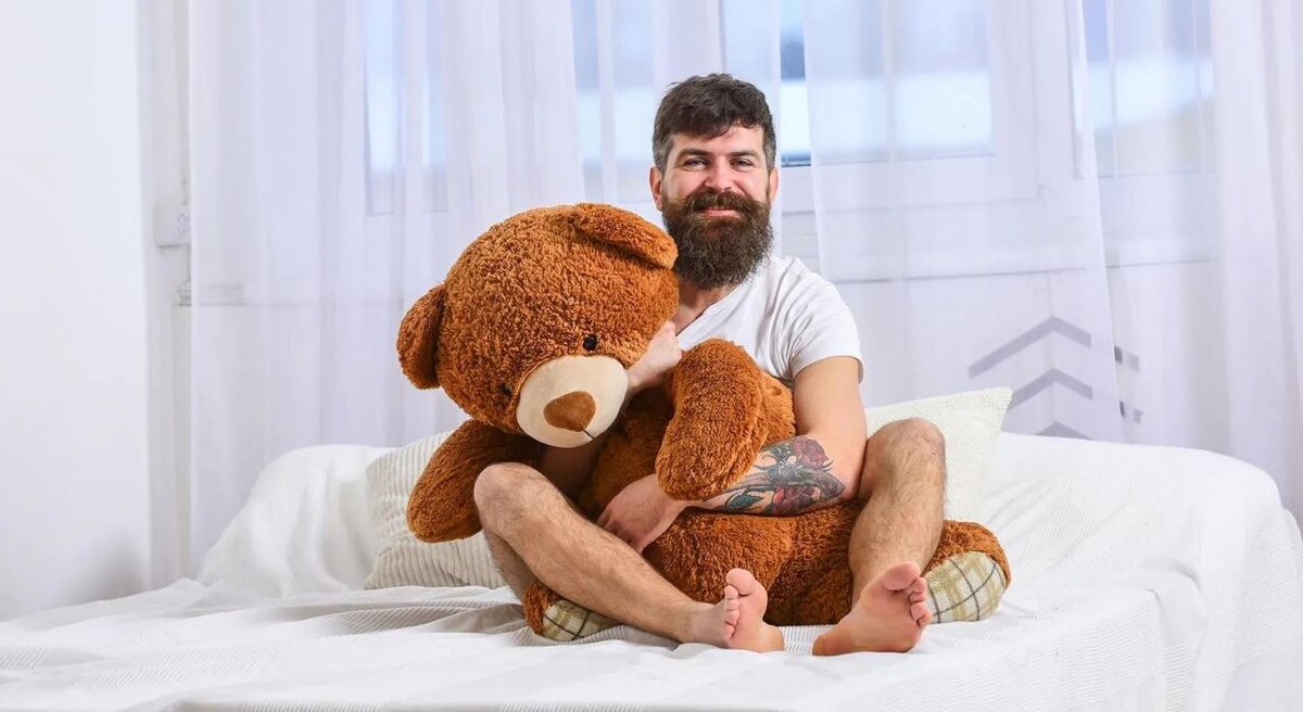 парень с плюшевым мишкой. мягкая игрушка мужик. мужчина с мишкой игрушкой. парень с большим плюшевым медведем. плюшевый медвежонок с цветами.