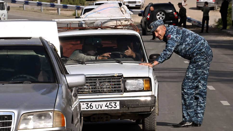 Фото: Анатолий Жданов / Коммерсантъ📷Сотрудник полиции и беженцы из Нагорного Карабаха на приграничном блок-посту в Корнидзоре