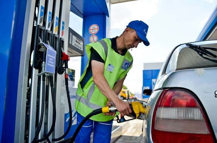 Вежливый работник заправляет авто