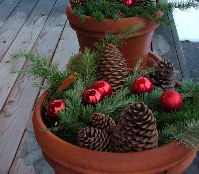 Цветочные горшки можно украсить шишками и шарами.