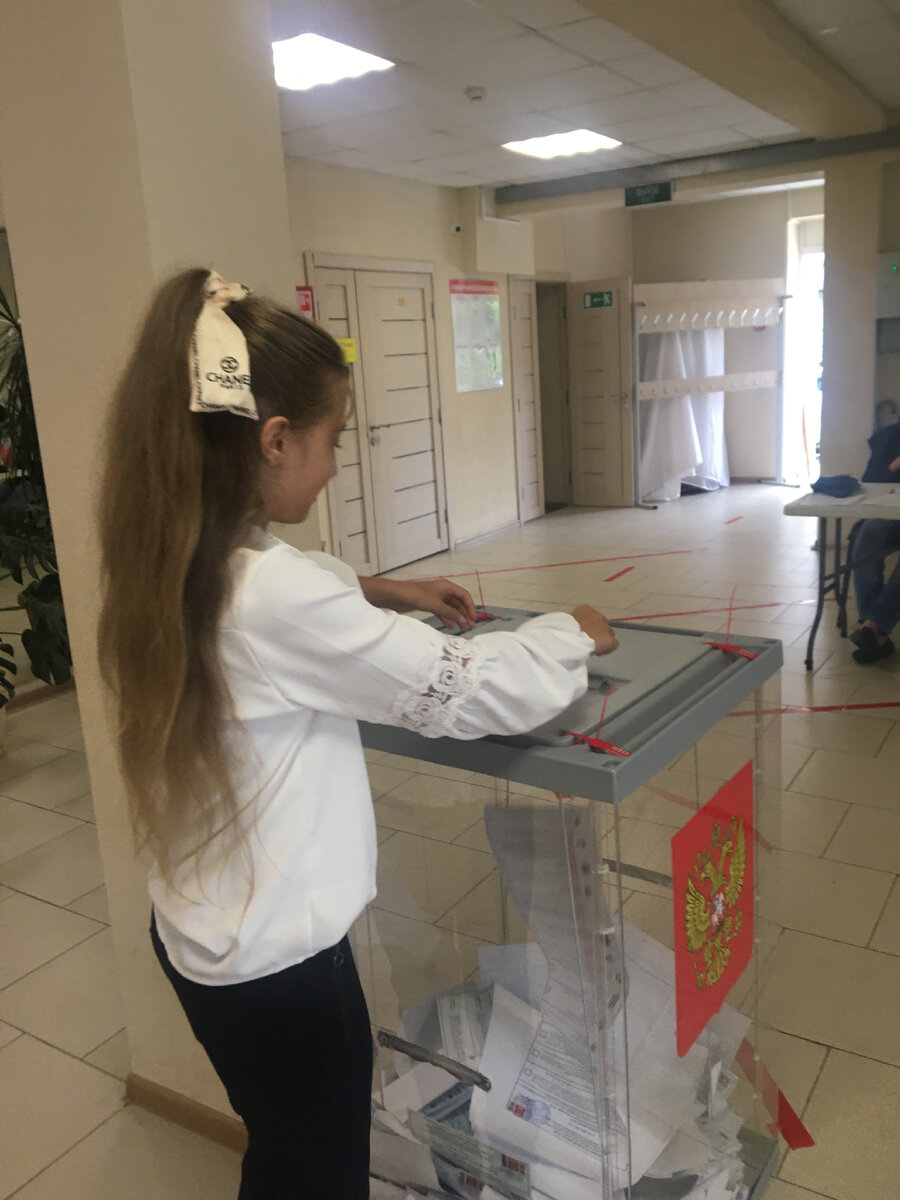 Фото:автора доча опускает бюллетени в урну