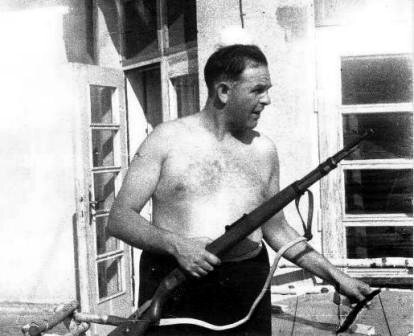 Амон Гёт на балконе своей виллы с винтовкой в руках.